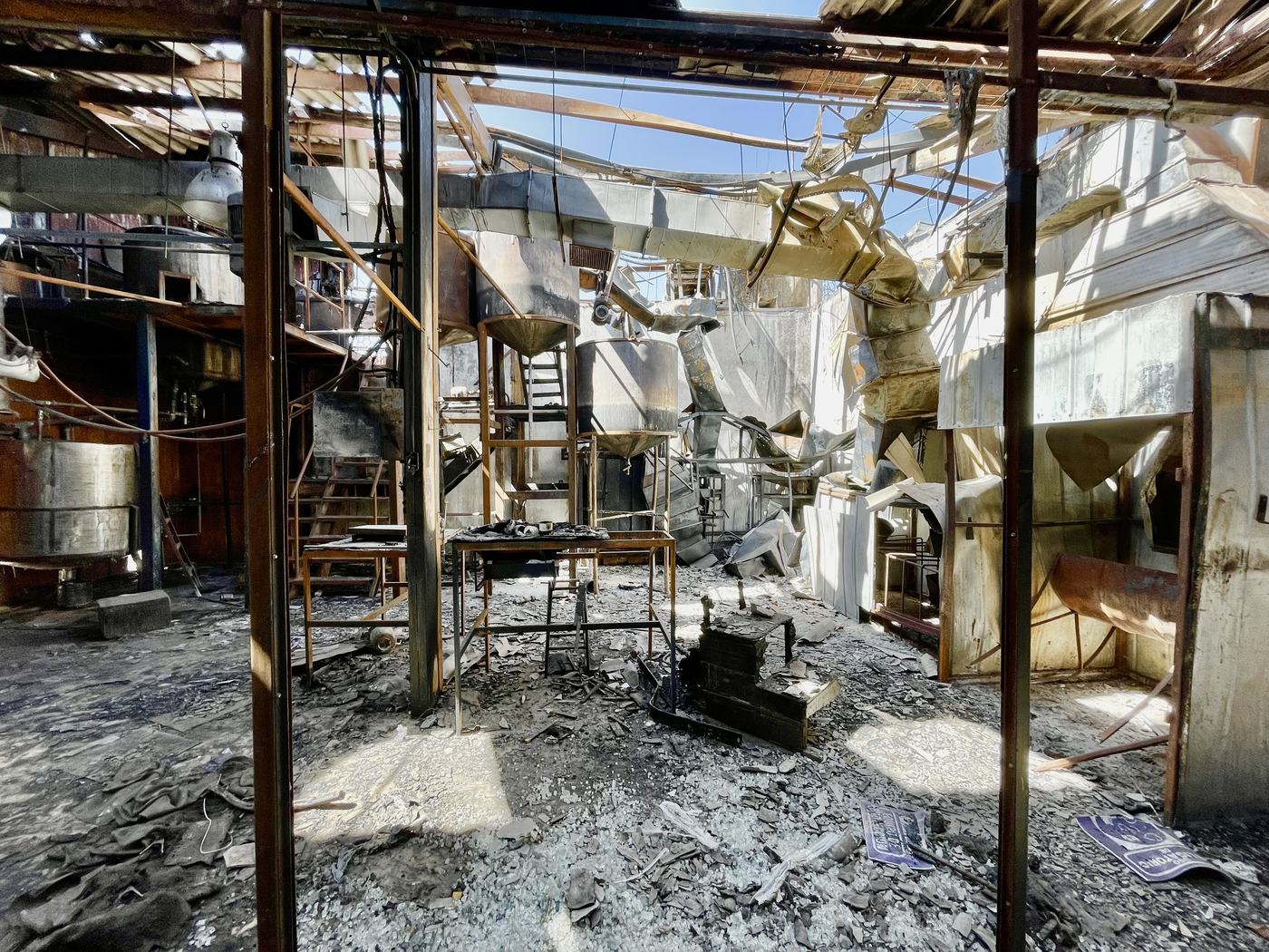 Interior de planta siniestrada por incendio con asbesto friable disperso sobre equipos